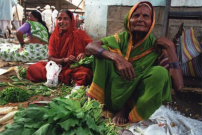 Sukabi Lokarne vendiendo en el mercado las verduras que cultiva en la tierra que pudo comprar gracias a un microcrédito.