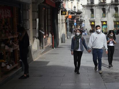 Varias personas protegidas con máscaras, en el centro de Madrid.