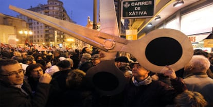 Unas enormes tijeras de cartón recorrieron ayer la manifestación de Valencia en protesta por los duros recortes sociales adoptados por el Consell.