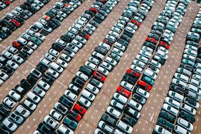 Creative pattern of a large number of cars parked outside in a row.