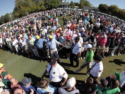 Tiger Woods, ayer, camino del <i>tee</i> del hoyo 1 para iniciar el primer recorrido.