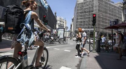 Una mujer con una bicicleta del servicio público de alquiler BiciMad.