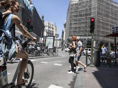 Una mujer con una bicicleta del servicio público de alquiler BiciMad.