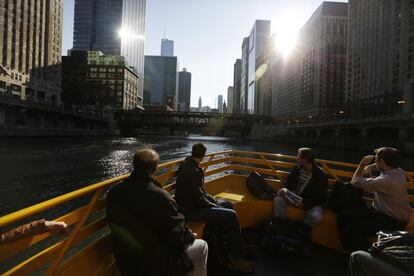 Uns ciutadans es traslladen amb vaixell pel riu Chicago fins a l'avinguda Michigan, Chicago (EUA).