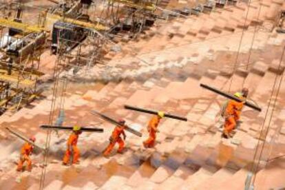 Un grupo de hombres trabaja en las obras de construcción del Estadio Nacional de Brasilia, sede de la Copa de las Confederaciones este año y del Mundial Brasil 2014 en Brasilia (Brasil). EFE/Archivo