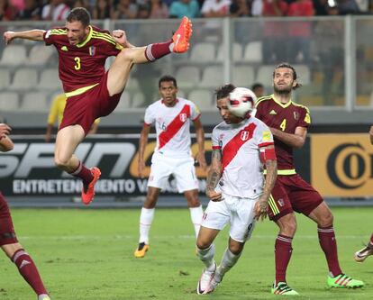 El jugador venezolano Mikel Villanueva disputa un balón con Paolo Guerrero, de Perú.