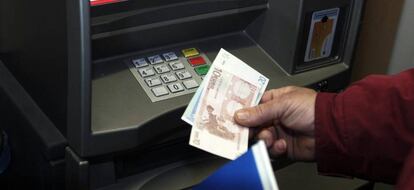 Un hombre retira euros de un cajero automático.
