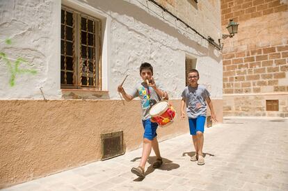 Dos niños pasean por las calles del casco antiguo de Ciutadella imitando al 'fabioler'.