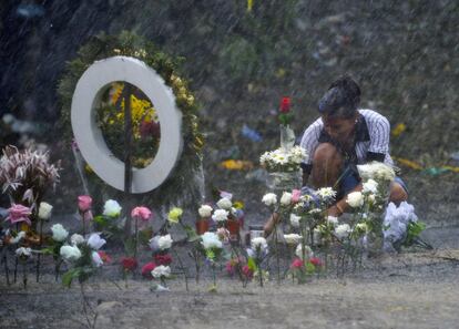 Una mujer pone flores en recuerdo a los 33 niños que murieron en el accidente de un autobús escolar en Fundación (Colombia).