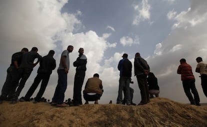 Unos palestinos observan las labores de rescate de Ham&aacute;s mientras buscan los restos de unos excavadores fallecidos en una operaci&oacute;n israel&iacute; contra un t&uacute;nel.