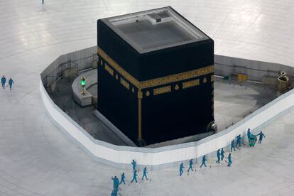 Varios trabajadores desinfectan el suelo alrededor de la Kaaba, en La Meca, debido a la covid-19.