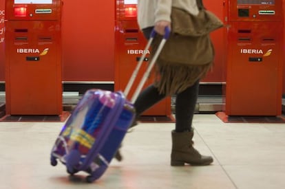 Una pasajera camina junto a las máquinas de facturación de Iberia.