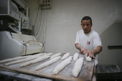 Un trabajador prepara barras de pan en el obrador de una panadería en Lugo.