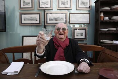 Juan Mari Arzak posa sentado en una de las mesas antiguas de su restaurante.