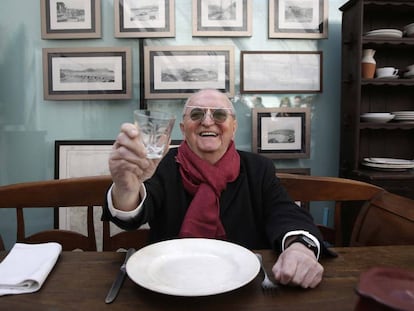 Juan Mari Arzak posa sentado en una de las mesas antiguas de su restaurante.