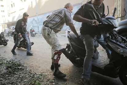 Un hombre herido intenta subirse a una motocicleta tras  un ataque israelí en el barrio de Mreijeh, en el sur de Beirut, este viernes.  