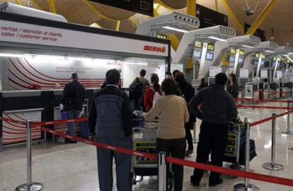 Un grupo de viajeros espera en los mostradores de Iberia.