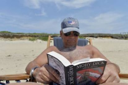 Un hombre lee Moby Dick en una playa de Nantucket.