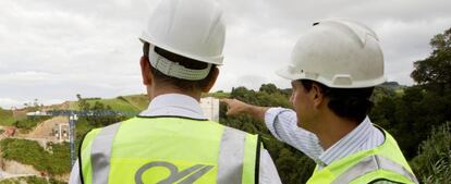 Dos ingenieros supervisan la construcci&oacute;n de un puente.