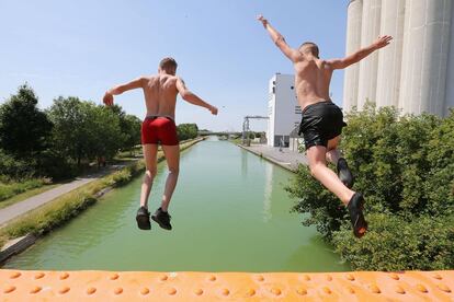 Dos niños saltan a un canal cerca de Reims, al norte de Francia, este martes.
