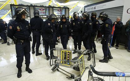 Un grupo de policía frente a un carro volcado en la T4 de Barajas