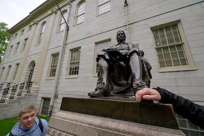 Un turista toca el pie de la estatua de John Harvard, como dicta la tradición, este viernes en el campus de la universidad.