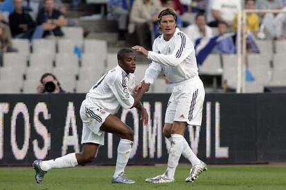 Beckham ayuda a levantarse a Robinho.