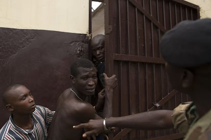 Reclusos de la prisión de Wango (Sudáfrica) tratan de salir de la celda ante la mirada de un vigilante.