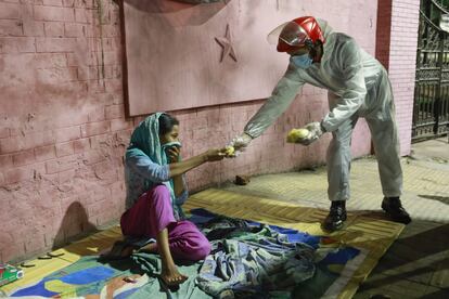 Una mujer sin hogar en Dhaka, Bangladesh recibe comida durante el confinamiento, en abril.