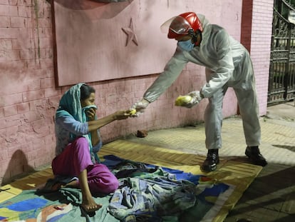 Una mujer sin hogar en Dhaka, Bangladesh recibe comida durante el confinamiento, en abril.