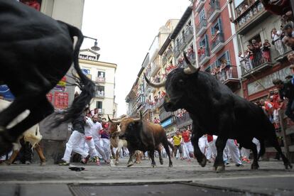 Uno de los toros de la ganadería madrileña de Victoriano del Río golpea a un mozo en la calle de La Estafeta durante el sexto encierro de los Sanfermines.
