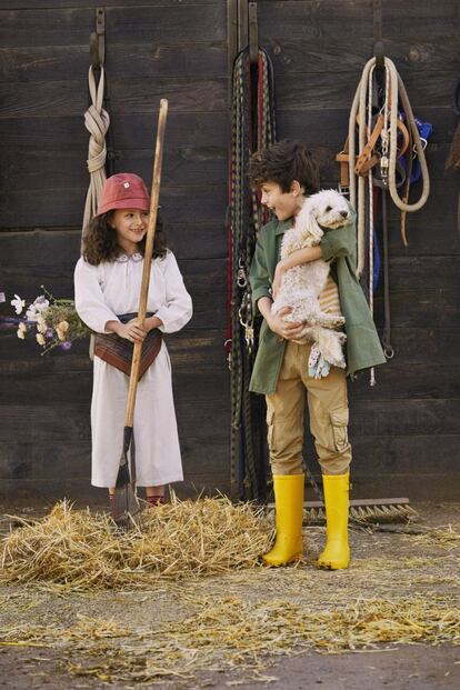 <b>Nicolás</b> lleva camisa verde con bolsillos de Melly Mellow, camiseta de rayas amarillas de Tinycottons, pantalones multibolsillos de Mayoral y botas de agua de Pisamonas. <b>Olivia</b> va con gorro de Wynken, blusa con cuello bordado de Caramel, pantalón de lino crudo de Bonnet à Pompon, pañuelo a la cintura de Bonton, calcetines de Caramel Baby & Child, zuecos de Pisamonas y ramillete de flores en la cintura de Los Peñotes.