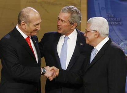 El primer ministro de Israel, Ehud Olmert (izquierda), estrecha la mano del presidente  palestino, Mahmud Abbas (derecha), en presencia de George W. Bush.