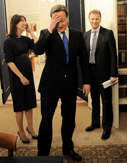 Sir Gus O&#39;Donnell (derecha), junto a David Cameron, el 11 de mayo de 2010, día en el que el primer ministro estrenaba junto a su esposa, Samantha, el 10 de Downing Street. Abajo, con Isabel de Inglaterra, durante una visita oficial de la reina al Cabinet Office, en junio de 2010.