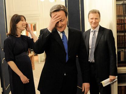 Sir Gus O'Donnell (derecha), junto a David Cameron, el 11 de mayo de 2010, día en el que el primer ministro estrenaba junto a su esposa, Samantha, el 10 de Downing Street. Abajo, con Isabel de Inglaterra, durante una visita oficial de la reina al Cabinet Office, en junio de 2010.