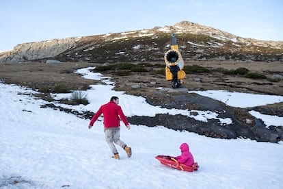 Javier Simón juega con su hija, junto a un cañón de nieve en Alto Campoó (Cantabria), el 22 de enero de 2024.