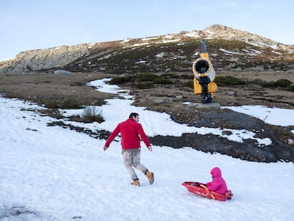 Javier Simón juega con su hija, junto a un cañón de nieve en Alto Campoó (Cantabria), el 22 de enero de 2024.