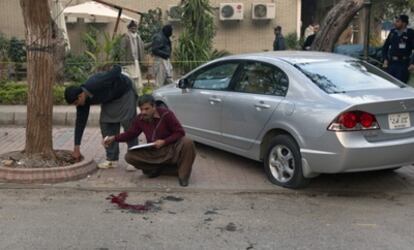 La policía inspecciona el coche de Salman Taseer y el lugar del tiroteo.