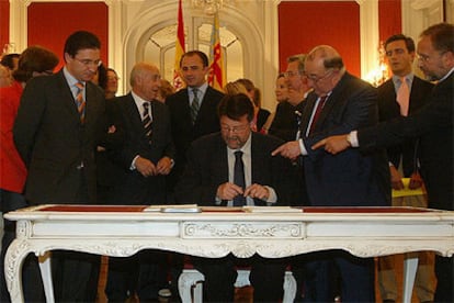 Un momento de la firma, ayer en las Cortes, de la proposición de ley de reforma del Estatut d&#39;Autonomia.