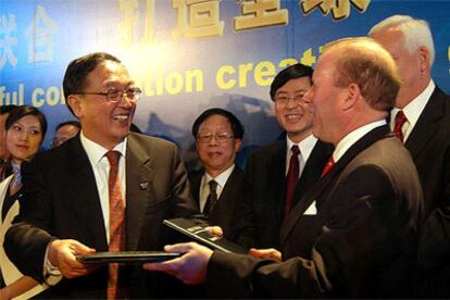 El presidente de Lenovo, Liu Chuanzi , bromea con John Joyce (IBM) tras la firma del acuerdo.