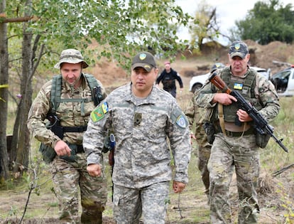 El general ucranio Serguéi Melnik visita el frente escoltado por varios soldados.