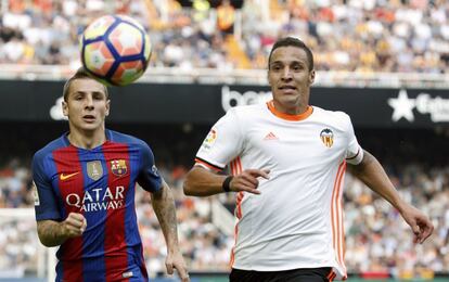 El defensa francés del FC Barcelona Lucas Digne (i) disputa un balón con el delantero del Valencia Rodrigo Moreno (d).