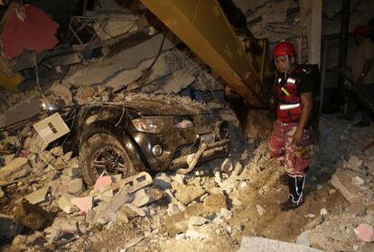 Un trabajador de rescate busca entre los escombros de una casa destruida en la ciudad costera del Pacífico de Pedernales, el 17 de abril de 2016.