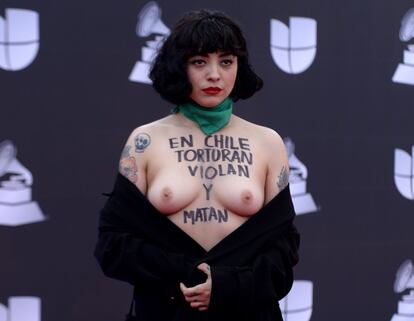 La cantante chilena Mon Laferte, expone su pecho en donde está escrito: "En Chile torturan, violan y matan", a su llegada a la 20a Entrega Anual del Latin Grammy en Las Vegas, el 14 de noviembre.
