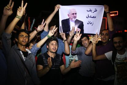 Jóvenes iraníes hacen el signo de la victoria con una foto de ministro de Relaciones Exteriores, Mohammad Javad Zarif, en la que se lee "Zarif es el Mosaddegh de nuestro tiempo". Comparan a Zarif a Mohammad Mosaddegh, el legendario primer ministro de Irán que durante la década de los 50 nacionalizó la industria petrolera del país, en Teherán, Irán.