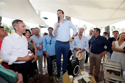 César Sánchez, a la izquierda, con camisa blanco, en un acto de apoyo a Pablo Casado, de pie en una silla, en las primarias del PP.