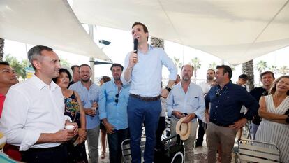 César Sánchez, a la izquierda, con camisa blanco, en un acto de apoyo a Pablo Casado, de pie en una silla, en las primarias del PP.