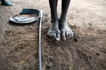 Los pies de la anciana partera Welge Konya entierran la placenta de Bai justo al lado de su cabaña en Dangaji. El índice de mortalidad materna en varios países de África supera los 1.000 por cada 100.000 nacimientos, aunque los objetivos de la ONU para el 2030 prevén fijar el límite mundial en 70. Actualmente, en la Unión Europea es de apenas ocho. En España, cinco