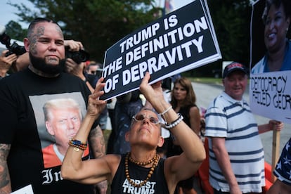 Un manifestante anti-Trump sostiene un cartel cerca de la entrada de la cárcel del condado de Fulton.