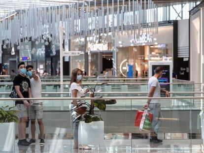  Personas con mascarillas en el interior del centro comercial Lagoh en Sevilla, este lunes.